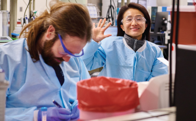 一位面带微笑的科学家在实验室与同事们一起工作。 一位面带微笑的科学家在实验室与同事们一起工作。