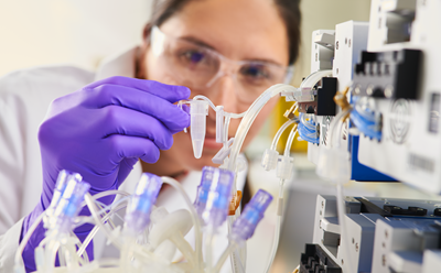 Pharma manufacturing bioreactor Woman collecting a small volume sample from Mobius Breez bioreactor