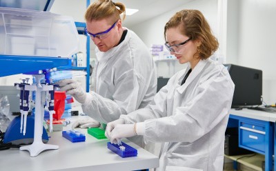 Laboratory Technicians Working with Equipment 两名身穿白大褂的实验室技术人员正在实验台上工作,使用科学设备、制备样品。