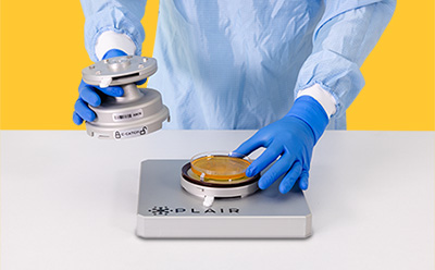 User Handling of C-Catch Unit-An Integrated Multi-jet impactor of Rapid-C+ System A technician in protective gear carefully handles a C-Catch unit while placing a petri dish on the monitoring platform.
