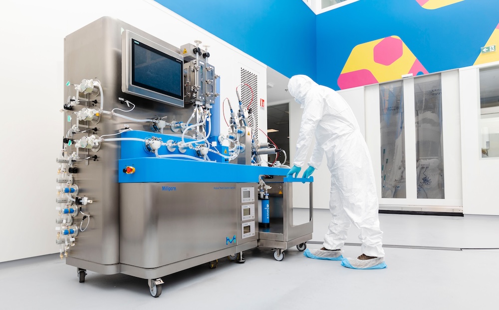Multi-column Chromatography System Operator, fully gowned, standing in front of the Mobius Multi Column Capture System