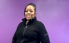Chevon Adams Chevon Adams wears a black fleece and stands in front of a purple wall.