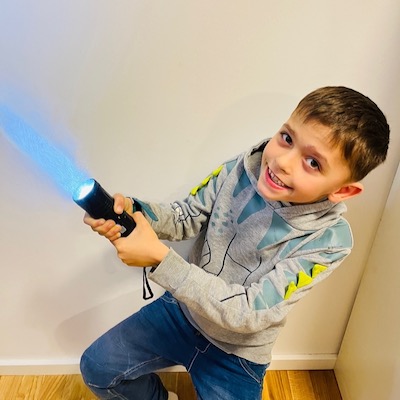 Léopol Kipping Léopol holds up a flashlight to imitate a light saber.
