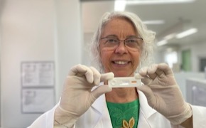 Samira Bührer Dr. Samira Bührer wears glasses, gloves and holds up a rapid test for Hansen’s disease.