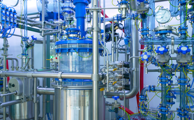 Commercial Lipids CDMO Services Close-up partial view of the Schaffhausen GMP pilot plant facility, featuring a 100-liter glass-lined reaction vessel and the glass-lined piping connected to and from the vessel.