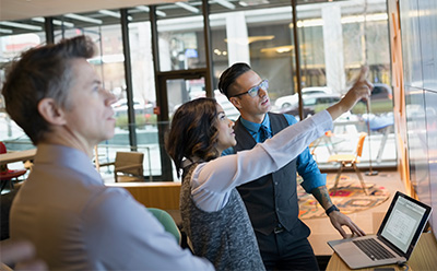 Group of people in a meeting looking at screens A group of people in a meeting