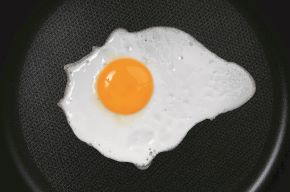 Egg on a Teflon frying pan View from above of an egg on cooking on a Teflon frying pan