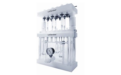 A laboratory apparatus called LiChrolut, which is used for solid-phase extraction. The device has multiple vertical columns and tubes, along with a pressure gauge, and is designed for processing multiple samples simultaneously.