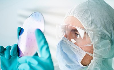 穿着防护服的科学家正在检查预制的预图案化电子器件基材