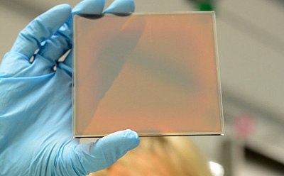 Thin-film solar cell 一名持着薄膜太阳能电池的科学家检查质量
