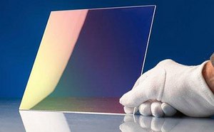 Image of 2-dimensional chalcogenide glass held upright by gloved hand to display the coating.