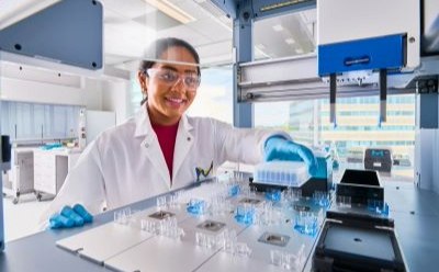 Scientist switching out components in the AAW™ workstation holding a plate Scientist switching out components in the AAW™ workstation holding a plate