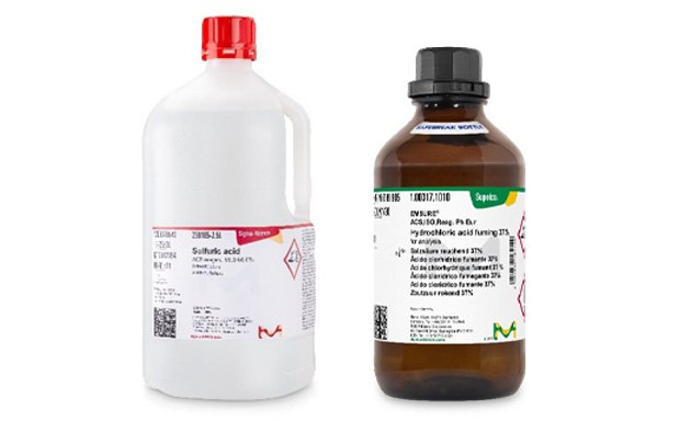 Two chemical bottles against a yellow background. On the left, a larger white bottle with a red cap and label indicating ‘Sulfuric acid, 95-98%’ with hazard symbols. On the right, a smaller amber bottle with a black cap and label reading ‘Hydrochloric acid, 37%’ also displaying hazard symbols.