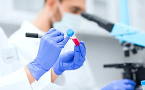 Laboratory worker filling out a label on a test tube