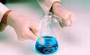 Lab worker sealing a flask with film