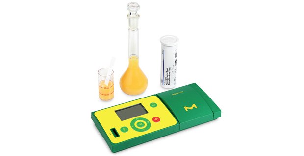 The portable RQFlex® 20 reflectometer with test strips, a beaker and a bottle.