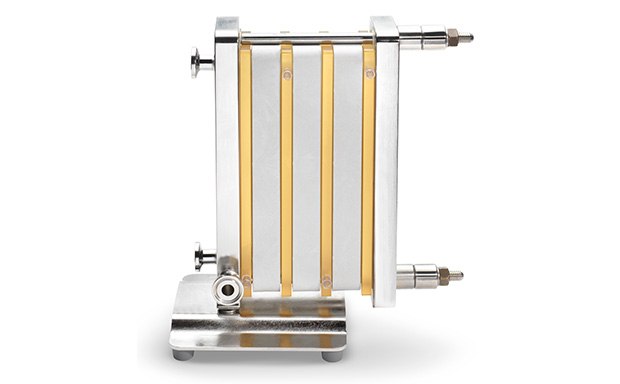 a tangential flow filtration device characterized by multiple yellowish tubes aligned vertically and parallel, connected to a metallic frame, with four rods securing the structure, and a robust metallic base for stability during operation.