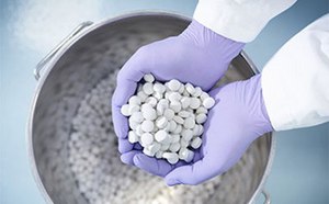 Solid-formulation-pills Newly produced tablets held in the gloved hands of a pharmaceutical worker