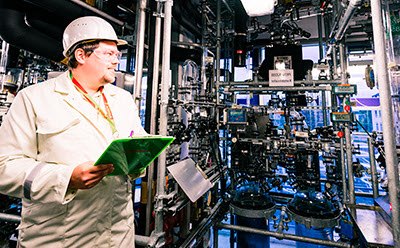 Manufacturing worker in a production area with pipes
