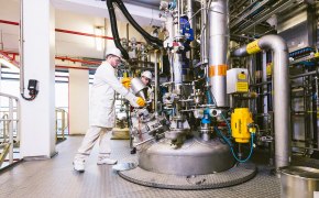 Scientists in production facility performing quality control and testing on production materials and bulk chemicals Scientists in production facility performing quality control and testing on production materials and bulk chemicals