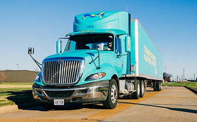 Company truck on a road, delivering materials to customers.