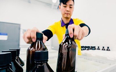 Worker packing glass bottles into a box