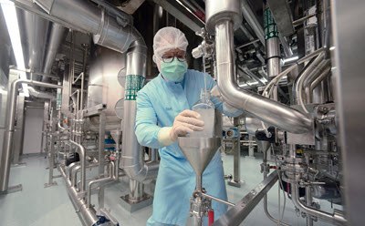 Manufacturing worker in a production area with pipes