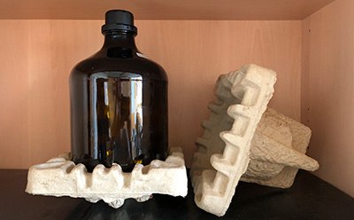 Glass bottle secured in recyclable molded pulp insert. Glass bottle secured in recyclable molded pulp insert.