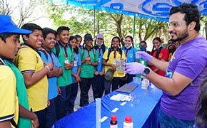 Curiosity Labs™ at Home A promotional poster for the SPARK™ program featuring a young child dressed in a white lab coat and safety goggles, symbolizing curiosity and scientific exploration. The vibrant blue background includes the text "Curiosity Experiments" and the SPARK™ logo, inviting viewers to engage with hands-on science activities.